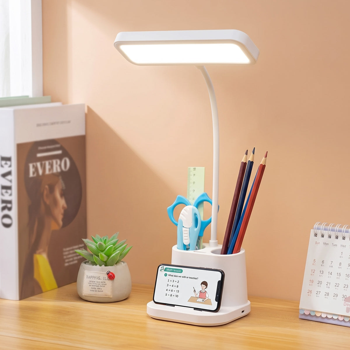 Lampe de bureau LED blanche avec pot à crayons et support pour téléphone, posée sur un bureau
