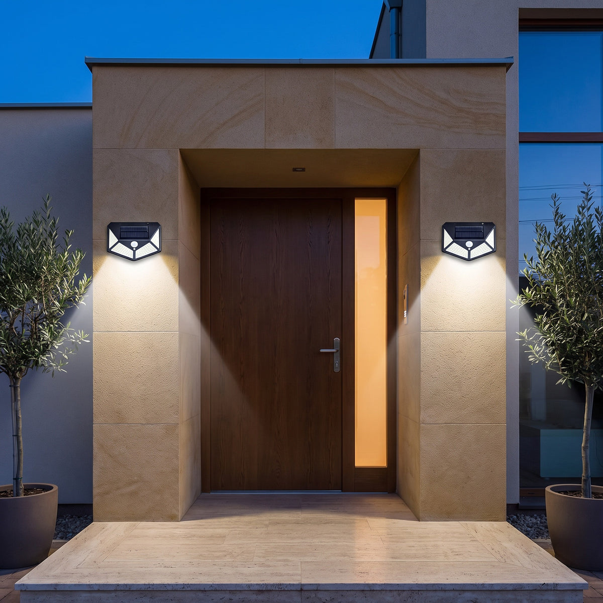 Deux lampes solaires 114 LED éclairant l'entrée d'une maison de chaque côté de la porte, le soir