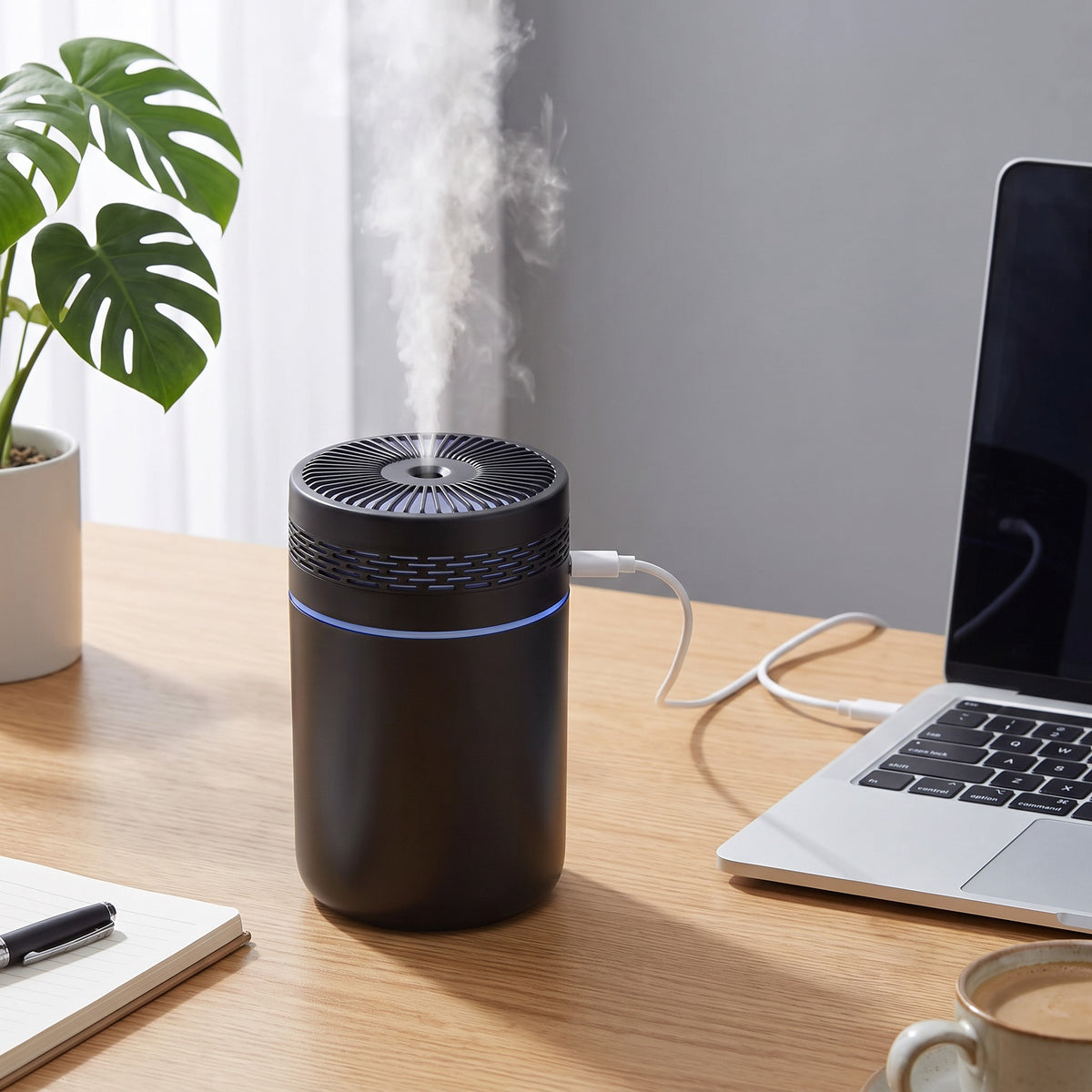 Mini-humidificateur d'air ultrasonique portable branché en USB à un ordinateur portable sur un bureau